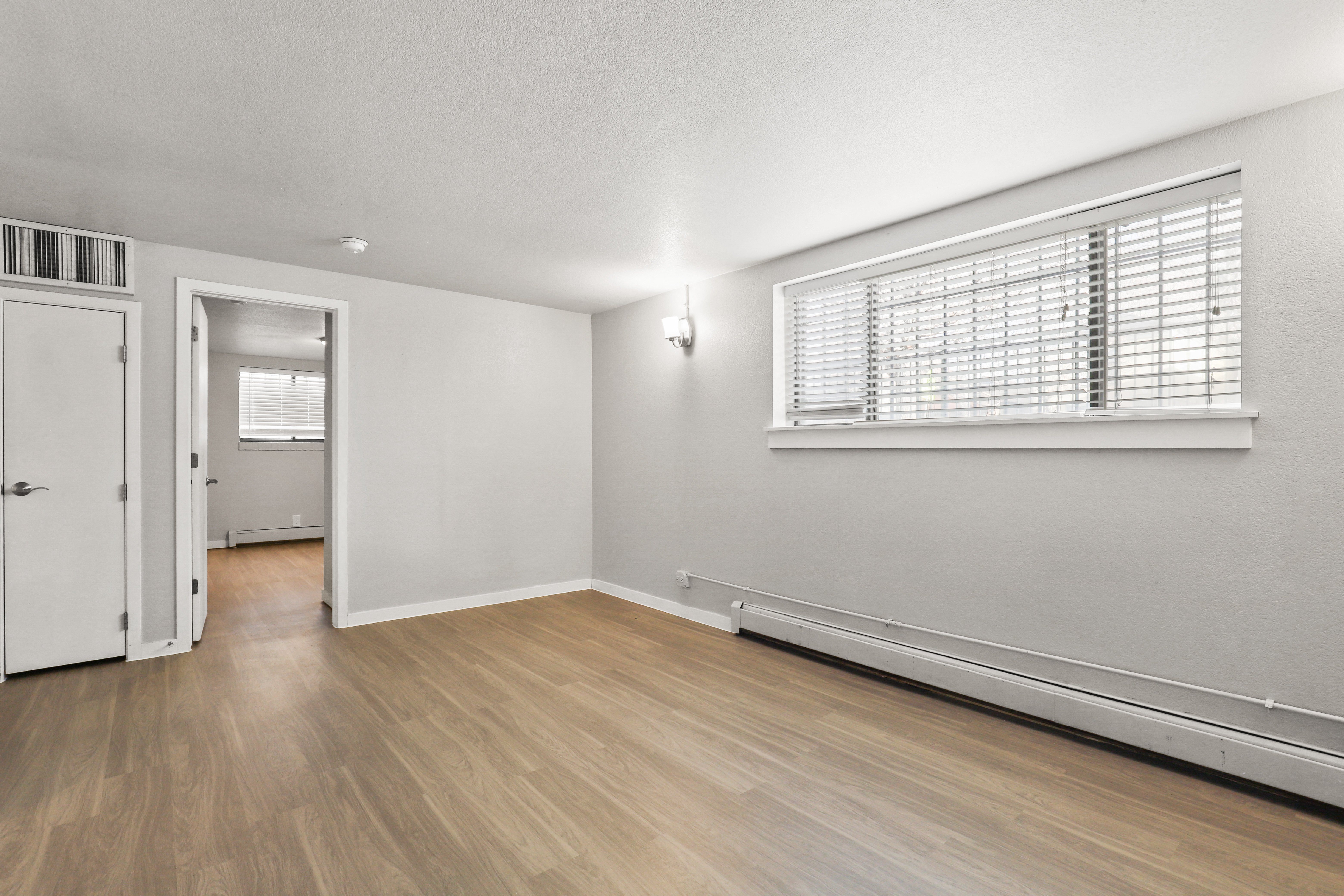 the living room of an empty house with a window and a door